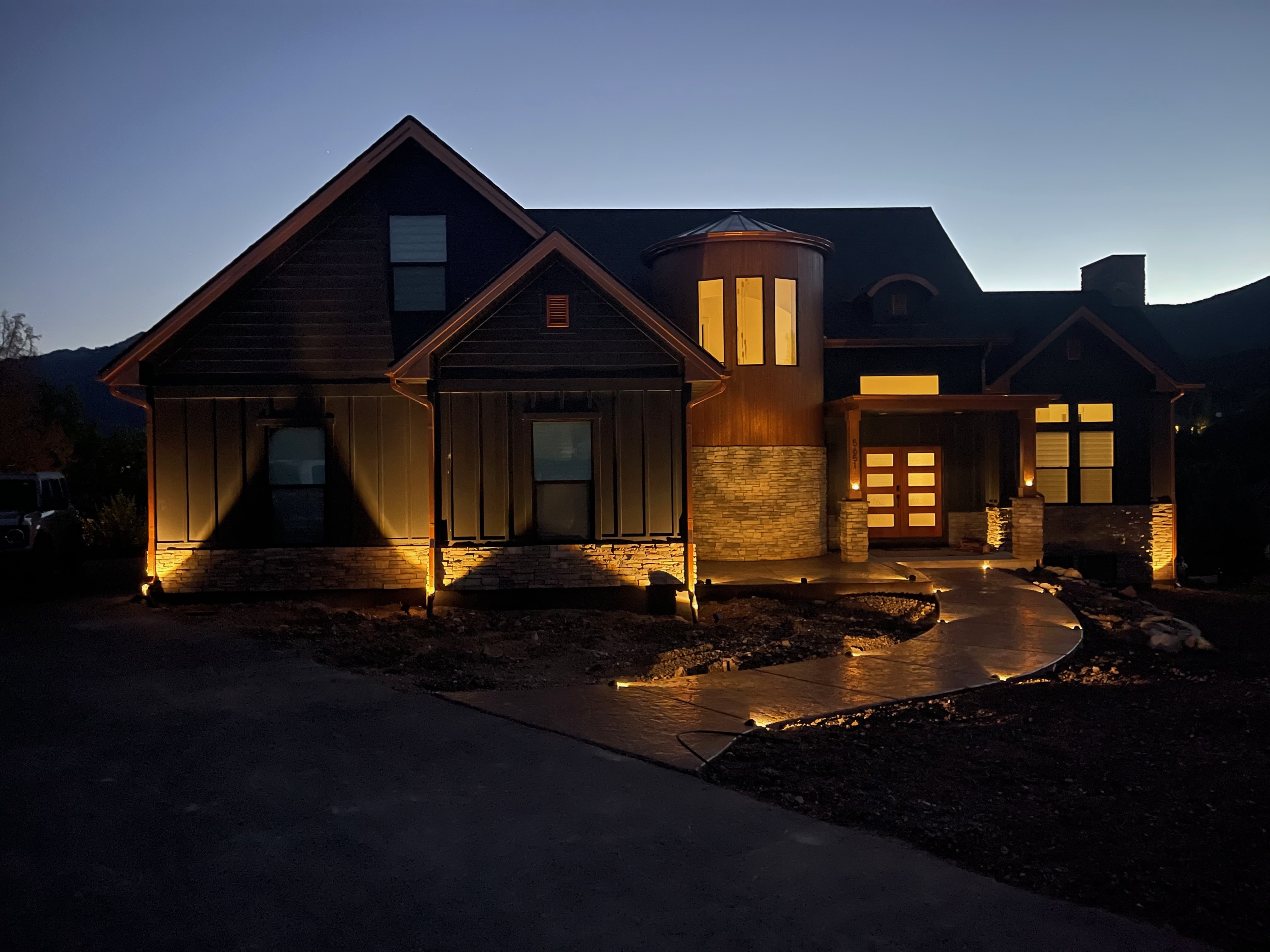 Custom home front entry with uplighting at dusk